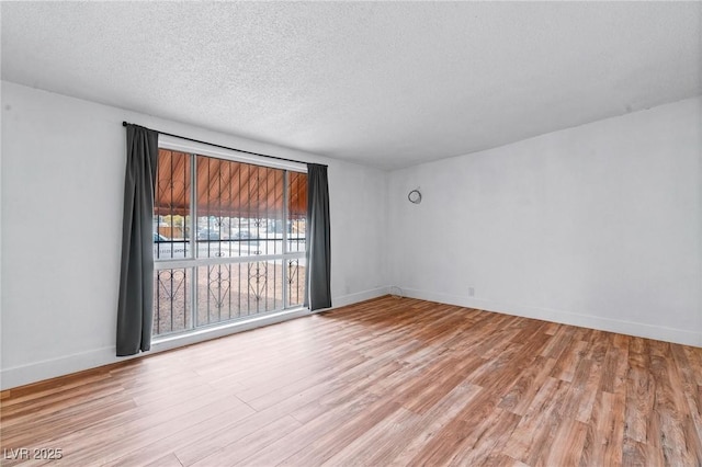 empty room featuring a textured ceiling and light wood-type flooring