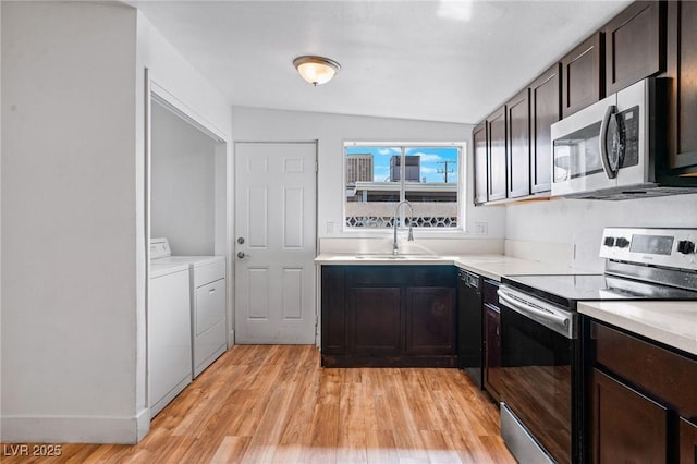 kitchen with sink, appliances with stainless steel finishes, dark brown cabinetry, washer and dryer, and light wood-type flooring