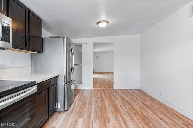 kitchen featuring dark brown cabinetry, light hardwood / wood-style flooring, and stainless steel appliances