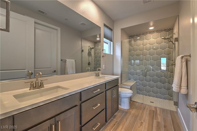 bathroom featuring vanity, an enclosed shower, and toilet