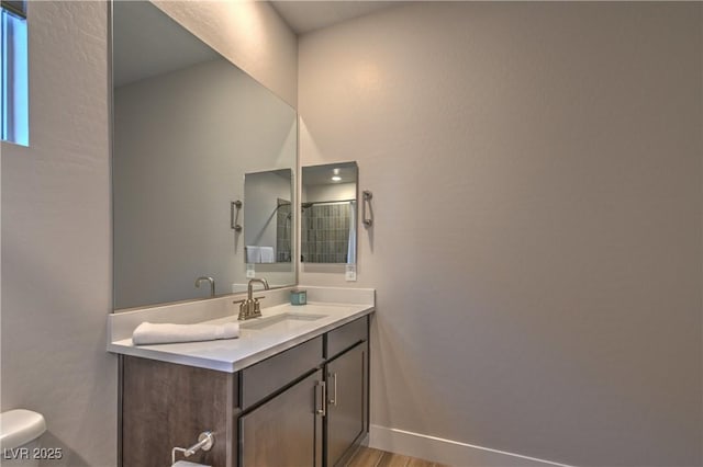 bathroom with vanity, wood-type flooring, and toilet