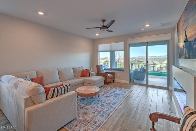 living room featuring light hardwood / wood-style flooring and ceiling fan