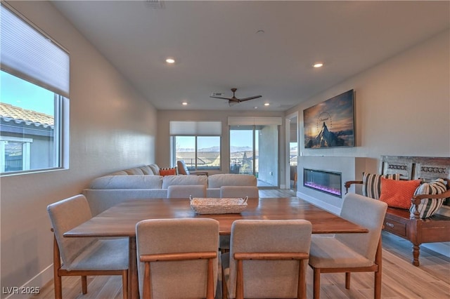 dining space with ceiling fan and light wood-type flooring