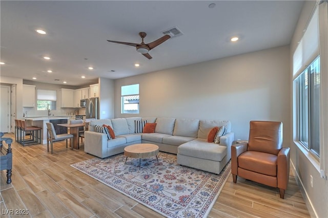 living room with ceiling fan and sink