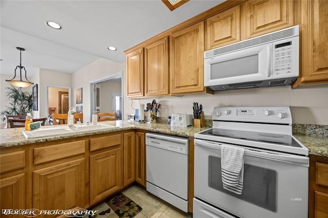 kitchen with sink, light tile patterned floors, pendant lighting, white appliances, and light stone countertops