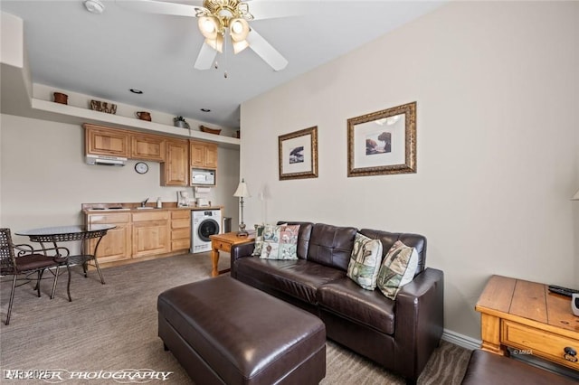 carpeted living room with ceiling fan and washer / clothes dryer