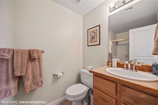 bathroom with tile patterned floors, vanity, toilet, and a shower with shower door