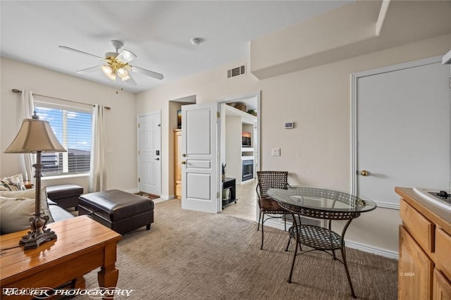 interior space with ceiling fan and light carpet