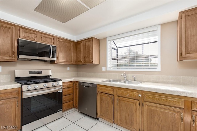 kitchen with sink, light tile patterned floors, and appliances with stainless steel finishes