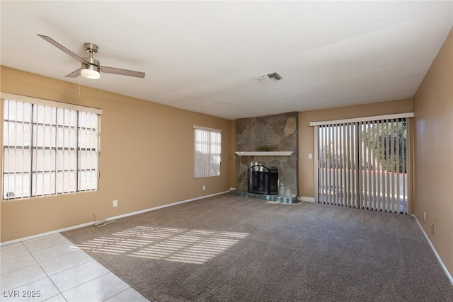 unfurnished living room with a fireplace, ceiling fan, and light tile patterned flooring