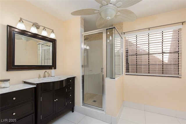 bathroom with ceiling fan, vanity, an enclosed shower, and tile patterned floors