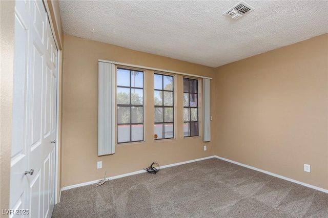 carpeted empty room with a textured ceiling