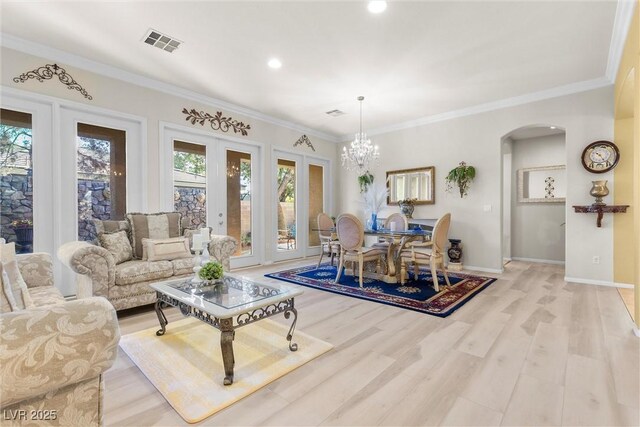 dining room with ornamental molding, a chandelier, and light hardwood / wood-style flooring