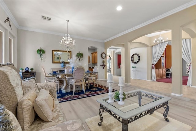 interior space featuring crown molding, an inviting chandelier, and light hardwood / wood-style floors