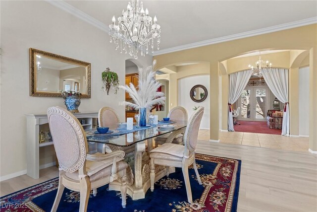 dining area featuring french doors, ornamental molding, hardwood / wood-style floors, and a notable chandelier