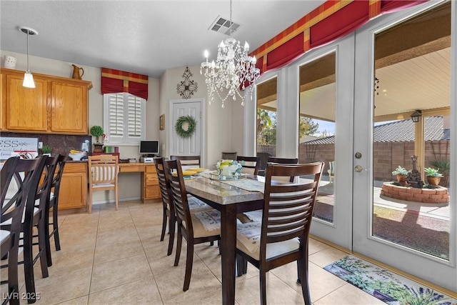 dining room featuring light tile patterned floors, a notable chandelier, and french doors