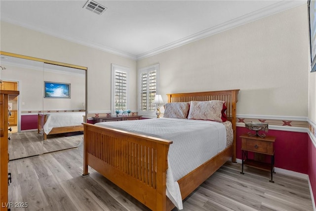 bedroom with crown molding, a closet, and light hardwood / wood-style flooring