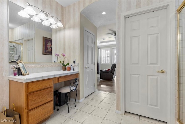 bathroom featuring tile patterned flooring, vanity, and a shower with shower door