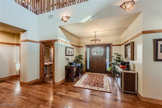 entrance foyer with wood-type flooring and a towering ceiling