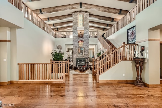 interior space featuring beam ceiling, hardwood / wood-style floors, and high vaulted ceiling