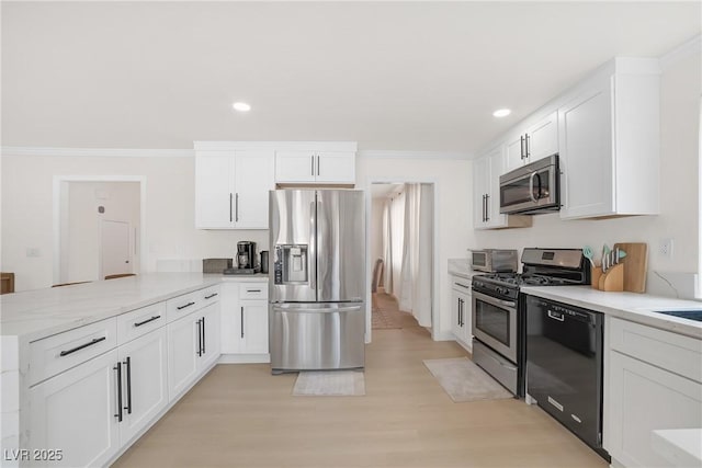 kitchen with ornamental molding, appliances with stainless steel finishes, white cabinets, and kitchen peninsula