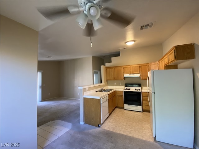 kitchen with sink, white appliances, light colored carpet, kitchen peninsula, and ceiling fan