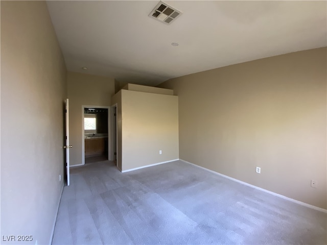 carpeted empty room featuring baseboards and visible vents