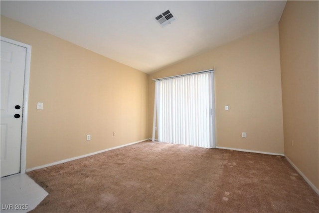 spare room featuring visible vents, baseboards, carpet floors, and lofted ceiling