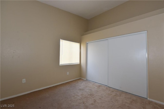 unfurnished bedroom featuring a closet, carpet, and baseboards