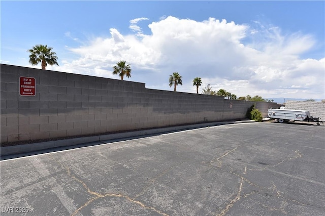 view of parking / parking lot featuring fence