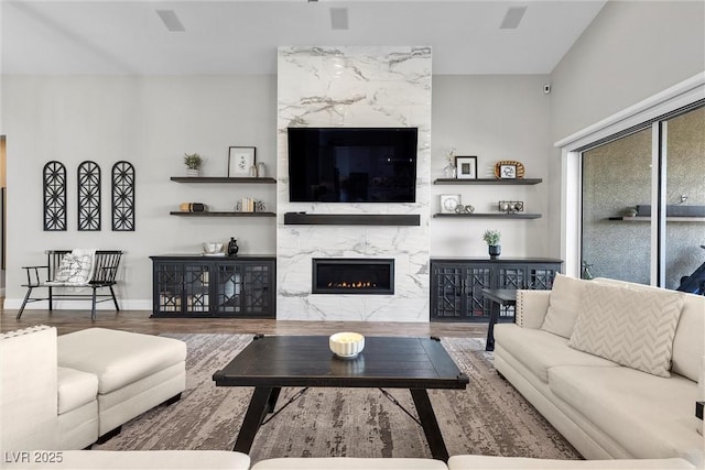 living room featuring a fireplace, wood finished floors, and baseboards