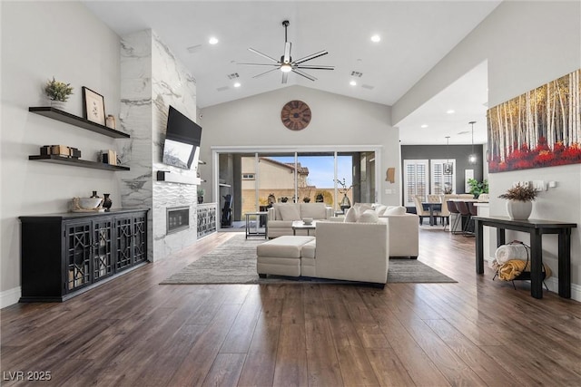 living room featuring visible vents, hardwood / wood-style floors, a fireplace, high vaulted ceiling, and recessed lighting