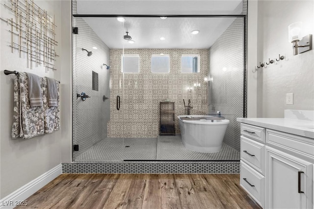 full bathroom with a freestanding bath, wood finished floors, vanity, and a shower stall