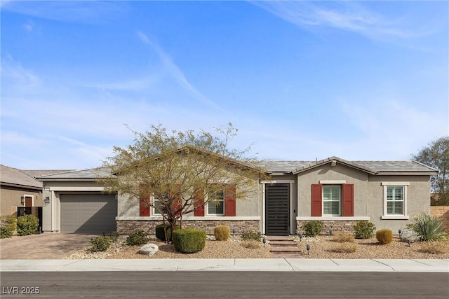 view of front of property with stone siding, driveway, an attached garage, and stucco siding