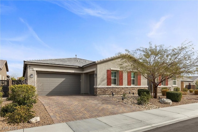 ranch-style home with stone siding, a tile roof, an attached garage, decorative driveway, and stucco siding