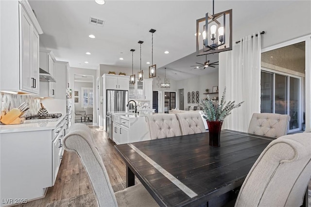 dining room featuring dark wood-style floors, recessed lighting, visible vents, and ceiling fan with notable chandelier