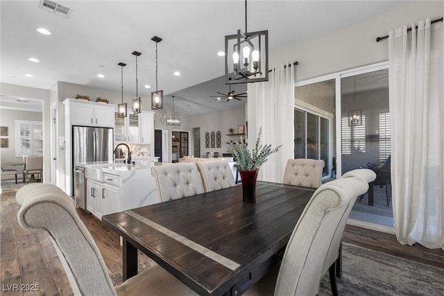 dining room with ceiling fan with notable chandelier, visible vents, dark wood-style flooring, and recessed lighting