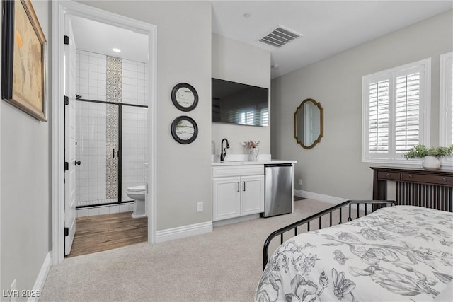 bedroom featuring light colored carpet, refrigerator, a sink, visible vents, and baseboards