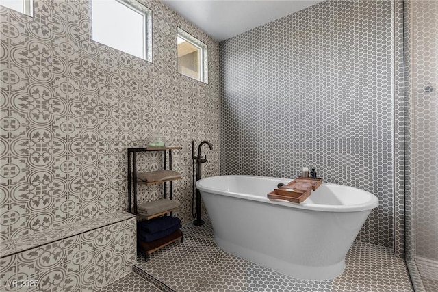 full bathroom with a freestanding tub and tile patterned flooring