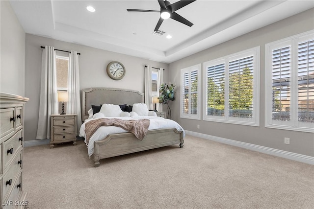 bedroom featuring recessed lighting, a raised ceiling, light colored carpet, and baseboards