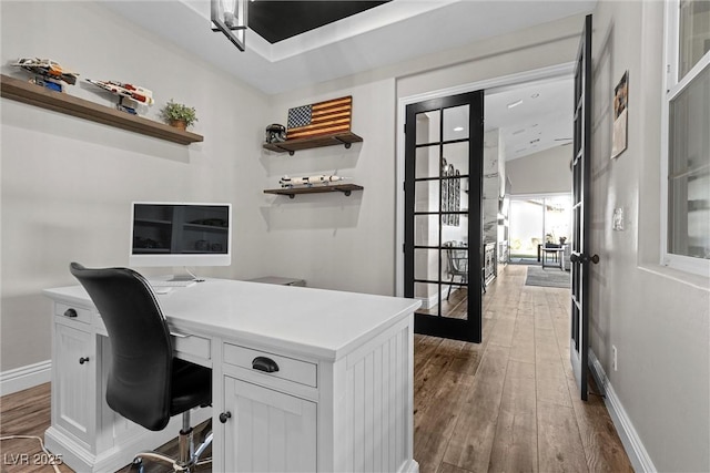 home office featuring french doors, wood finished floors, and baseboards