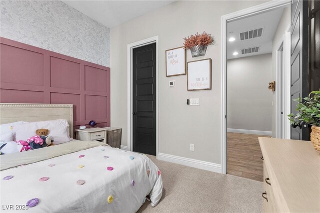 bedroom with light colored carpet, visible vents, and baseboards