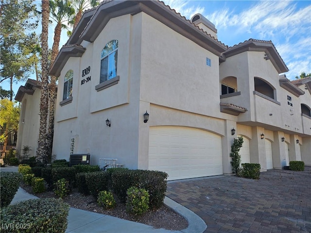 view of property exterior with a garage and central air condition unit