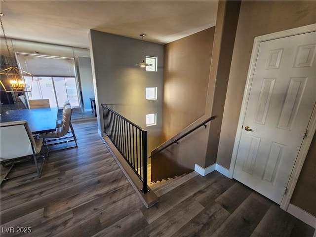 stairway with an inviting chandelier and wood-type flooring