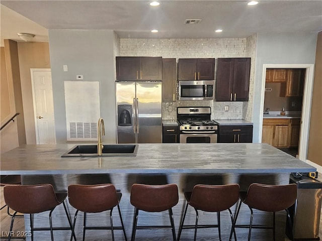 kitchen featuring appliances with stainless steel finishes, a kitchen breakfast bar, and sink