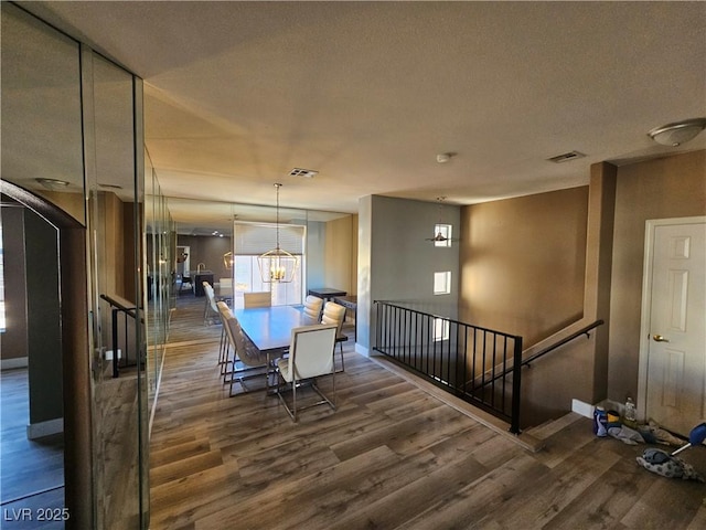 unfurnished dining area with dark wood-type flooring and a textured ceiling