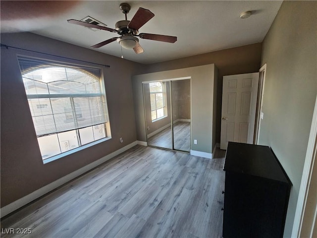 unfurnished bedroom with ceiling fan, light hardwood / wood-style floors, and a closet