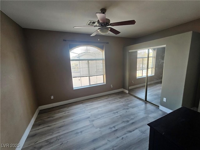 unfurnished bedroom featuring light hardwood / wood-style flooring, a closet, and ceiling fan