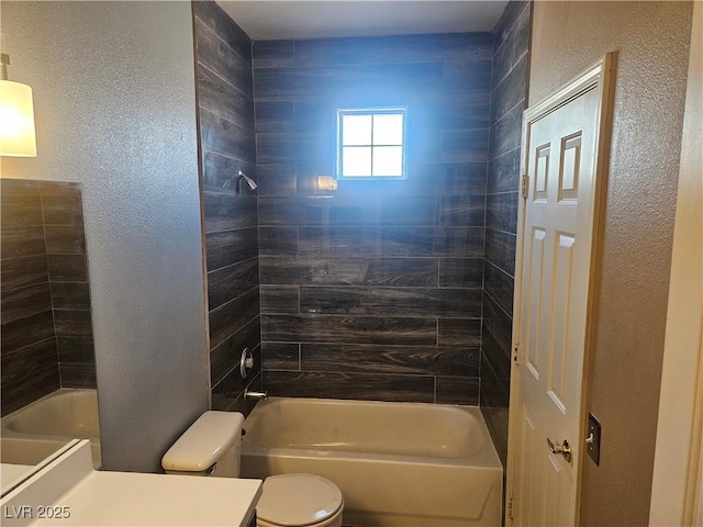 full bathroom with tiled shower / bath, vanity, and toilet