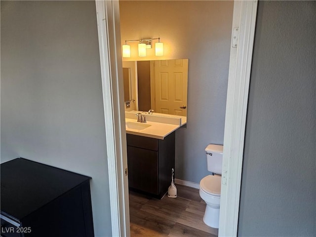 bathroom featuring hardwood / wood-style flooring, vanity, and toilet